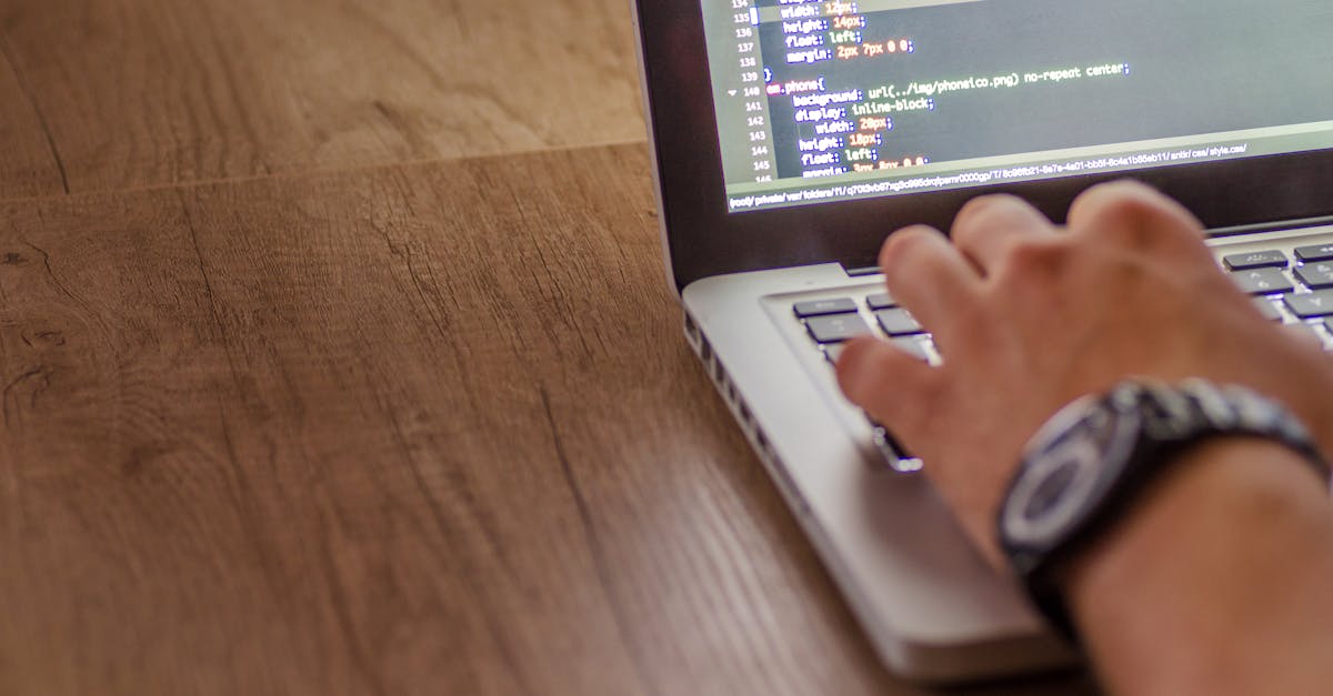 Close-up of a person coding on a laptop, showcasing web development and programming concepts.
